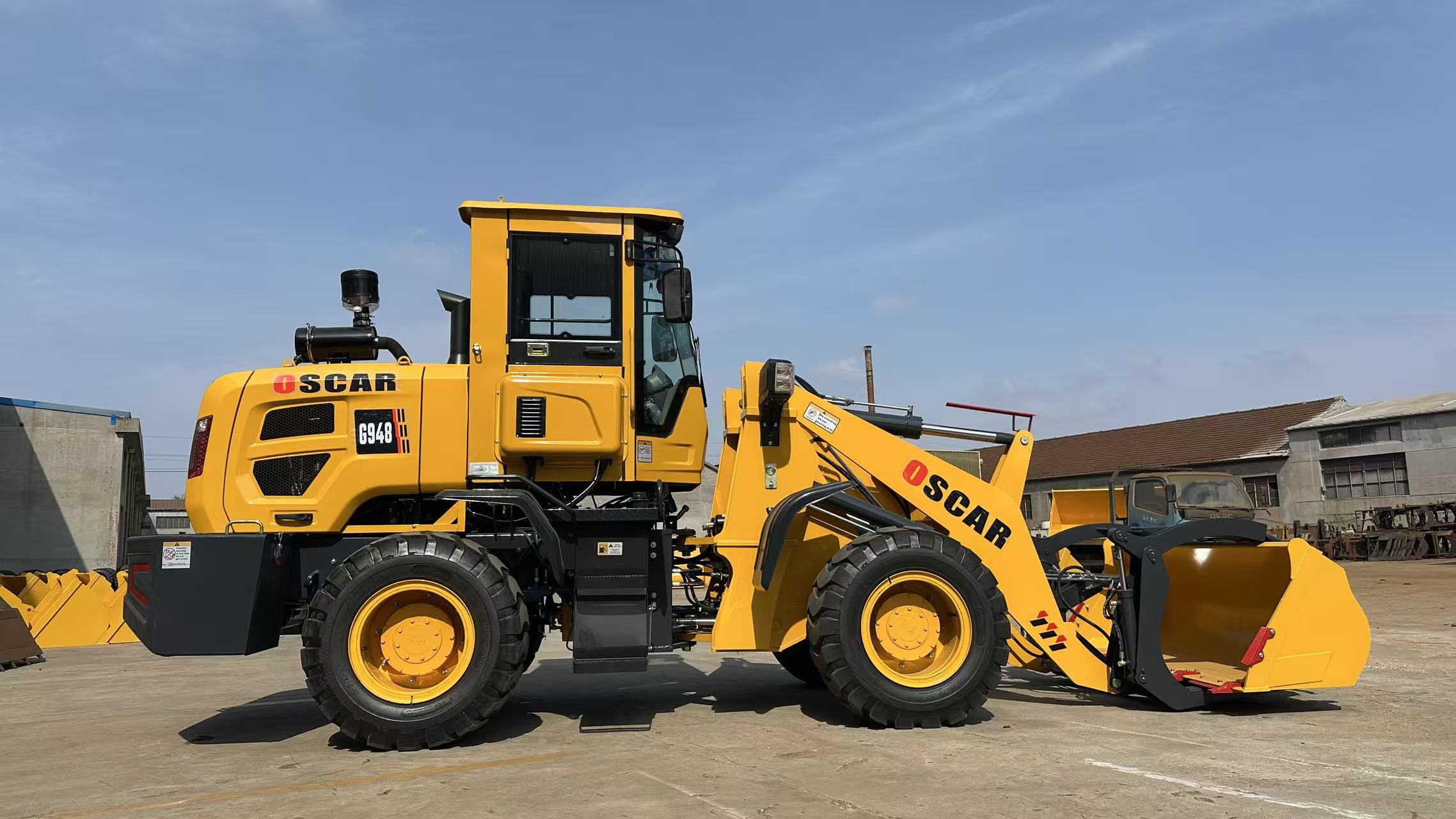 Yellow wheel loader side profile in factory yard